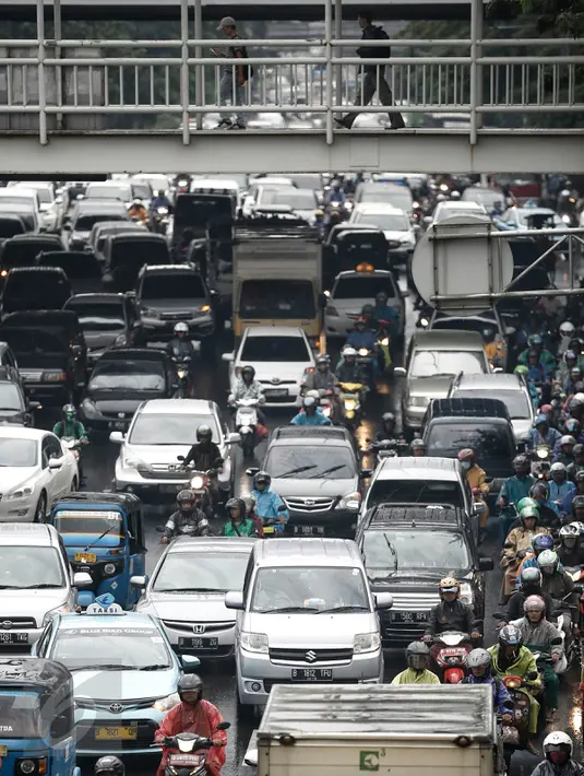 Antrean kendaraan yang terjebak kemacetan di Jalan Pramuka, Jakarta, Jumat (26/2). Banjir yang menggenangi sejumlah ruas jalan menyebabkan kemacetan arus lalu lintas di beberapa titik. (Liputan6.com/Faizal Fanani)