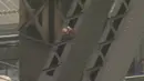 Seorang pria berbaju hitam dan berkaca mata sedang menaiki jembatan Sydney Harbour, Australia, (17/6). Belum diketahui motif apa yang membuat pria tersebut menaiki jembatan yang menjadi landmark Australia tersebut. (SEVEN NETWORK/via REUTERS TV)