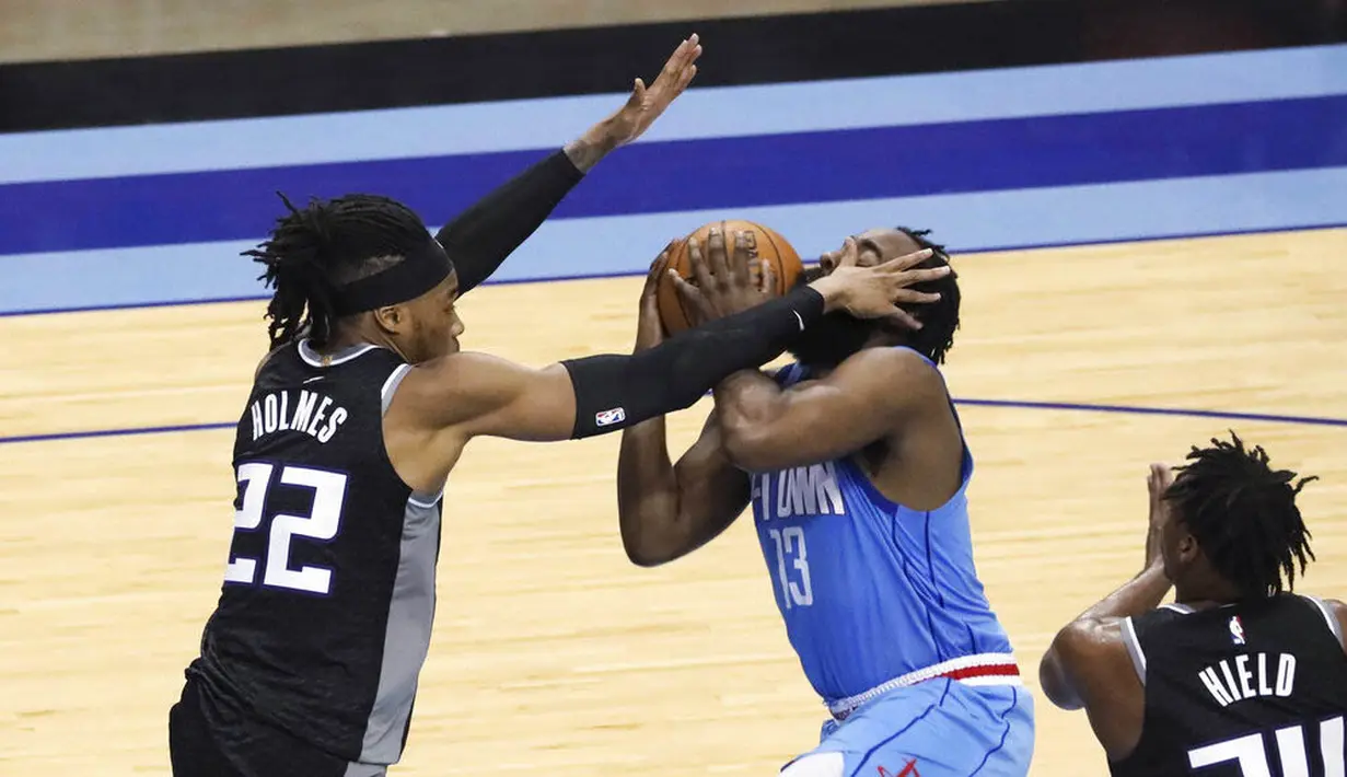 Pebasket Houston Rockets, James Harden, dihadang pebasket Sacramento Kings, Richaun Holmes, pada laga NBA, Jumat (1/1/2021). Houston Rockets menang dengan skor 122-119. (AP/Richard Carson)
