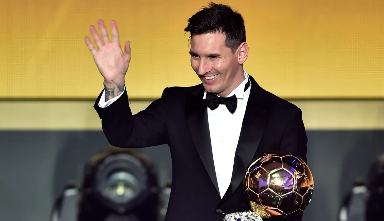 Pemain Barcelona, Lionel Messi melambaikan tangan sambil memegang trofi setelah memenangkan pemain terbaik dunia FIFA Ballon d'Or 2015 di Kongresshaus, Zurich, Senin ( 11/1). Ini adalah kelima kalinya Messi meraih Ballon d'Or. (AFP PHOTO/FABRICE COFFRINI)