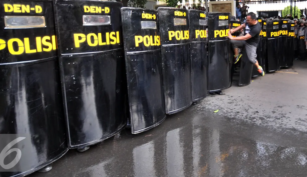Demonstran bentrok dengan petugas saat simulasi pengamanan jelang pendaftaran Calon Gubernur dan Wakil Gubernur DKI Jakarta Periode 2017-2022 di Kantor KPU Pusat, Jakarta, Jumat (16/9). Pendaftaran dimulai 21-23 September 2016. (Liputan6.com/Johan Tallo)