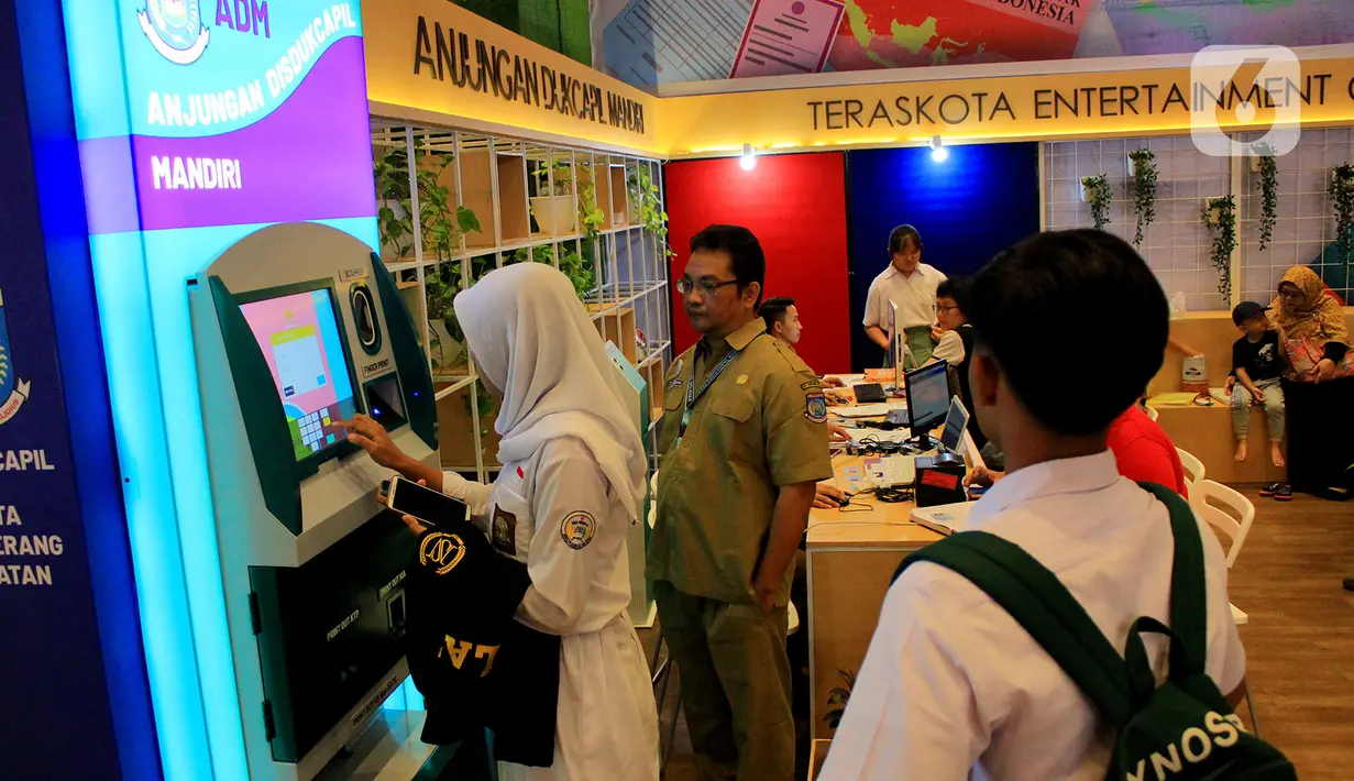 Petugas mendampingi seorang pelajar yang hendak mencetak Kartu Tanda Penduduk (KTP) lewat Anjungan Dukcapil Mandiri (ADM) di Teras Kota, Serpong, Tangerang Selatan, Banten, Senin (24/2/2020). Mesin ADM dapat mencetak tujuh pelayanan administrasi kependudukan bagi masyarakat. (merdeka.com/Magang/Muha