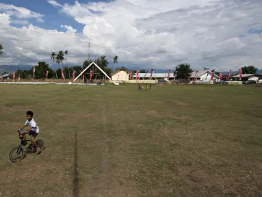 Seorang anak bermain sepeda di Lapangan Sepak Bola Kota Palu, Sigi, Sulteng, Selasa (8/3). Rencananya di lapangan tersebut, Wapres Jusuf Kalla dan istrinya, Mufida Kalla akan menyaksikan fenomena Gerhana Matahari Total. (Liputan6.com/Immanuel Antonius)