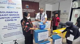 Petugas merapikan APD (Alat Pelindung Diri) dari Saint Gobain Group di kantor Sudin Kesehatan Jakarta Selatan Kamis (2/4/2020). Bantuan untuk tenaga medis di 8 RSUD di Jakarta Selatan berupa 950 buah surgical gloves dan 300 buah hooded coverall. (Liputan6.com/HO/Iwan)