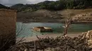 Foto ini menunjukkan sisa-sisa rumah yang muncul kembali ketika permukaan danau buatan Mornos menurun akibat kekeringan, di desa Kallio, sekitar 240 km barat laut Athena, Yunani pada 3 November 2025. Ini adalah ketiga kalinya desa tersebut muncul kembali, setelah peristiwa serupa terjadi selama kekeringan lain pada awal 1990-an, September 2024. (Angelos TZORTZINIS/AFP)