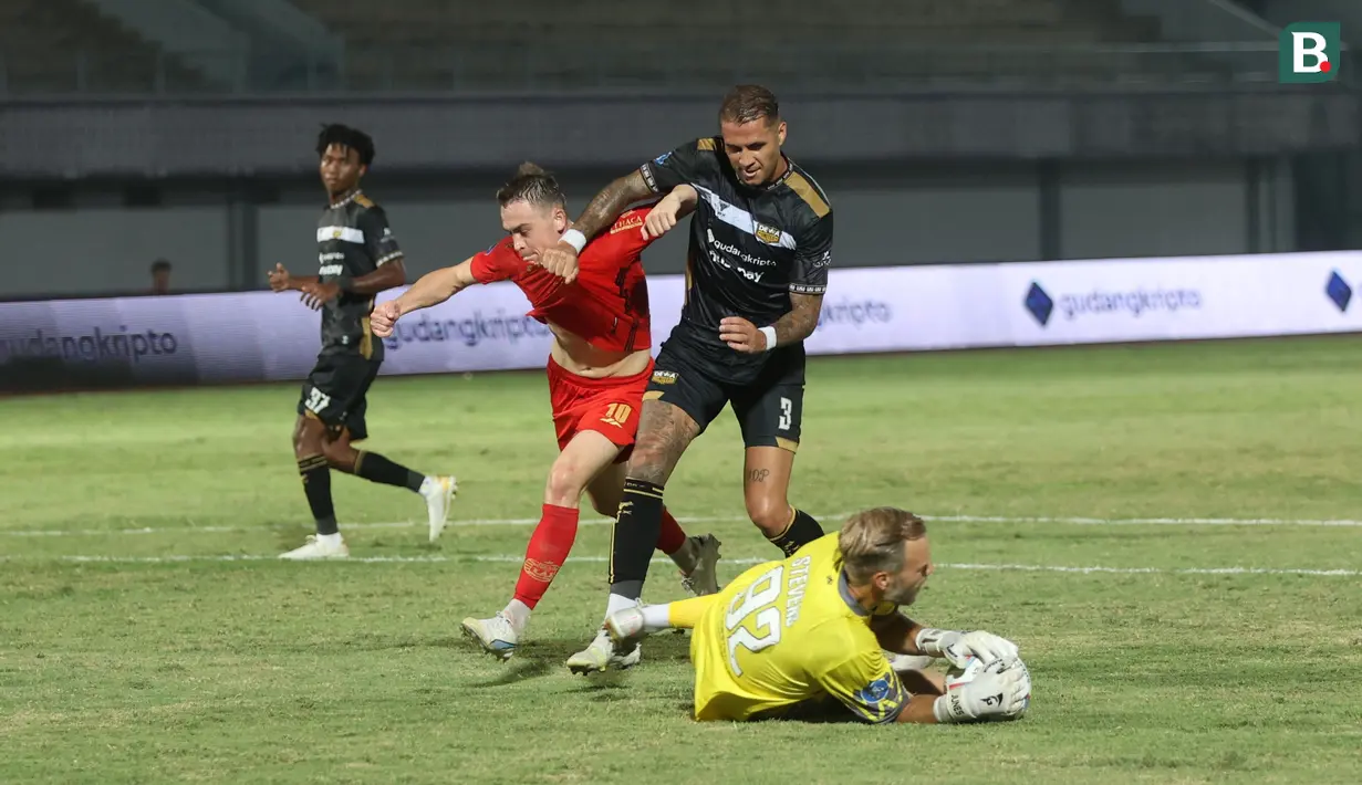 <p>Kiper Dewa United, Sonny Stevens berhasil menangkap bola dari ancaman pemain Persija Jakarta, Maciej Gajos (kiri) yang dikawal ketat Junior Eldstal pada laga pekan ke-10 BRI Liga 1 2023/2024 di Stadion Indomilk Arena, Tangerang, Jumat (25/8/2023). (Bola.com/M Iqbal Ichsan)</p>