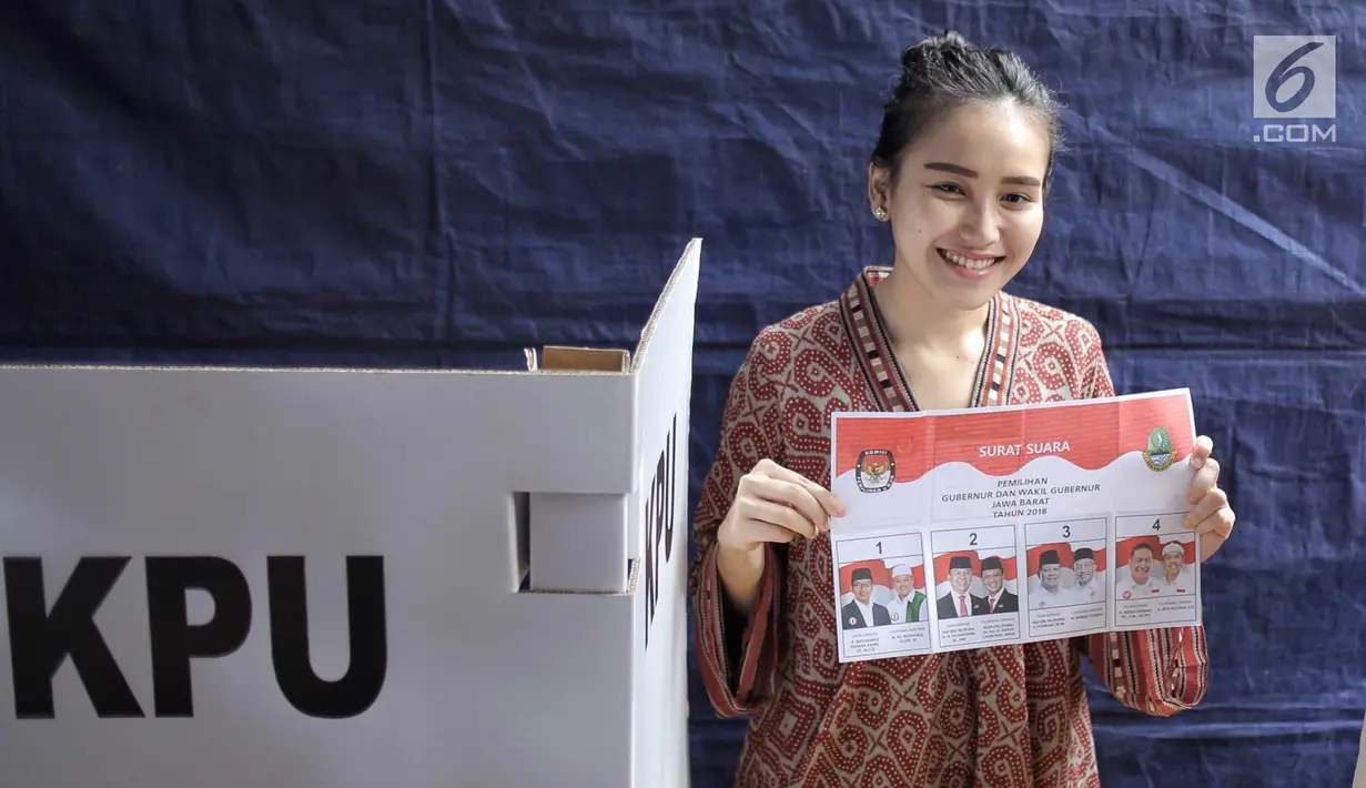 Penyanyi dangdut Ayu Ting Ting memperlihatkan surat suara sebelum mencoblos pada Pilkada Serentak 2018 di  TPS 5, Sukma Jaya, Depok, Rabu (27/6). Kota Depok bersiap menentukan gubernur Jawa Barat untuk 5 tahun mendatang. (Liputan6.com/Faizal Fanani)
