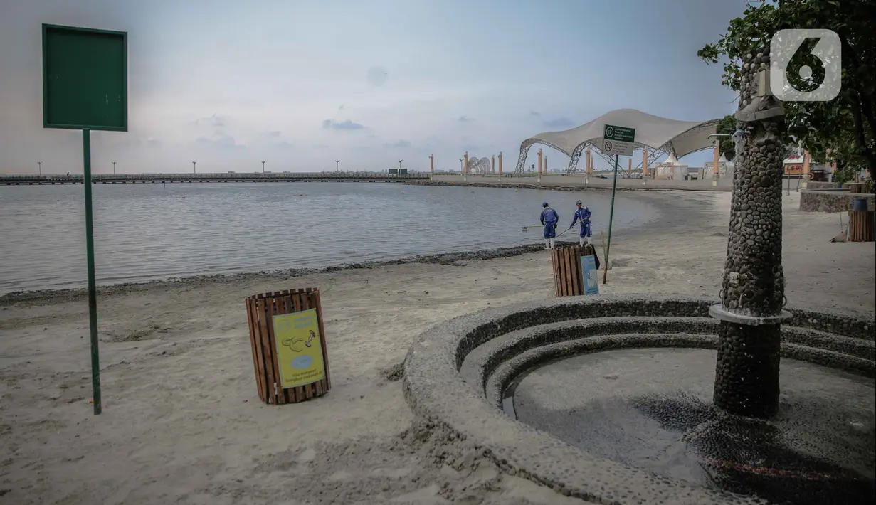 Petugas membersihkan pantai ancol yang sepi usai ditutup antisipasi COVID-19, Jakarta, Sabtu (14/3/2020). Selama masa penutupan, Taman Impian Jaya Ancol akan melakukan kegiatan overhaul seluruh wahana dan membersihkan fasilitas rekreasi dengan disinfektan. (Liputan6.com/Faizal Fanani)