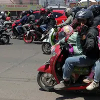 Sejumlah pemudik bersepeda motor melintas di Jalan Raya Brigadir Jenderal Darsono, Cirebon, Jawa Barat, Minggu (7/4/2024). (Liputan6.com/Herman Zakharia)