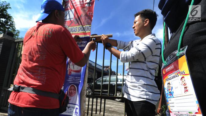 Petugas Bawaslu melakukan pencopotan alat peraga kampanye (APK) Pemilu 2019 di kawasan Lebak Bulus, Jakarta Selatan, Minggu (14/4). Pencoptan yang melibatkan tenaga PPSU ini sebagai tindak lanjut masa tenang Pemilu 2019 hingga hari pencoblosan 17 April mendatang. (merdeka.com/Arie Basuki)
