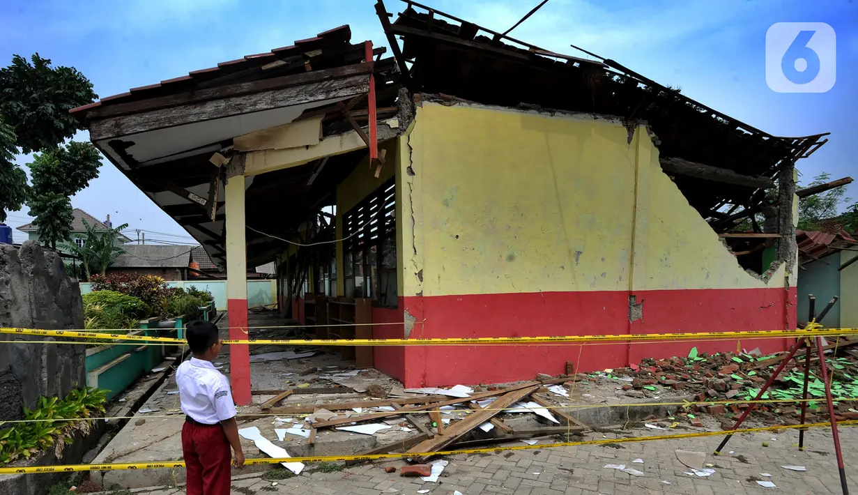 Siswa melihat bangunan sekolah yang ambruk di SDN Malangnengah II di Kampung Jaha, Desa Malang Negah, Kec. Pangedagang, Kabupaten Tangerang, Banten, Rabu (13/11/2019). Tiga ruang kelas di SD itu roboh akibat kontur tanah di lingkungan sekolah yang ambles karena hujan. (merdeka.com/Arie Basuki)