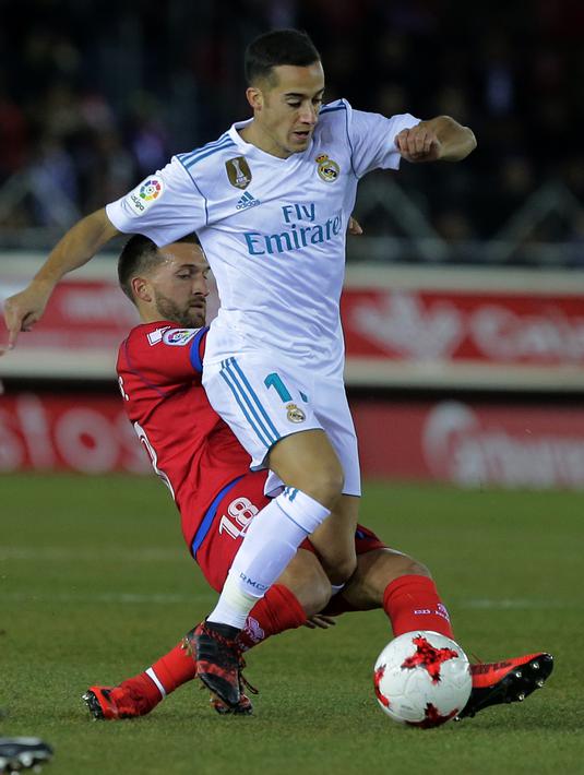 Aksi pemain Real Madrid, Lucas Vazquez (kanan) melewati adangan pemain Numancia, Grego pada laga Copa Del Rey di Nuevo Estadio Los Pajaritos stadium, Soria, (4/1/2018). Madrid menang 3-0. (AFP/Cesar Manso)