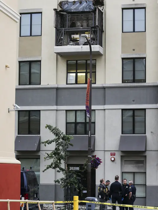 Sejumlah polisi terlihat berjaga di sekitar lokasi runtuhnya balkon di lantai 4 dari sebuah apartemen di California, AS, 16 Juni 2015. Enam orang mahasiswa yang berada di balkon itu dikabarkan terjatuh dan tewas. (REUTERS/Elia Nouvelage)