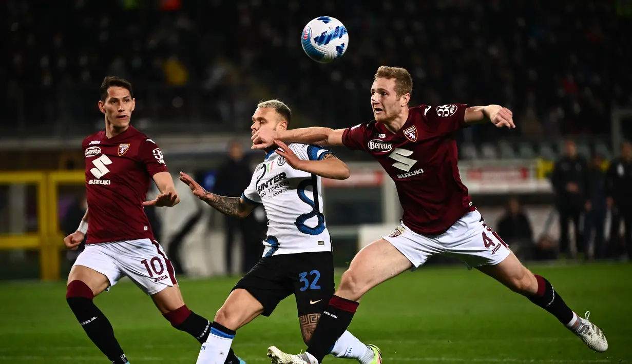 Gelandang Torino, Sasa Lukic dan Tommaso Pobega berebut bola dengan bek Inter Milan Federico Dimarco selama pertandingan lanjutan Liga Serie A Italia di stadion Olimpiade di Turin, Senin (14/3/2022). Dengan hasil ini Inter Milan turun ke peringkat ketiga dengan 59 poin. (AFP/Marco Bertorello)