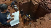 Tim ekskavasi menggali sumuran atau bagian tengah Situs Srigading Malang. Di tiap sudut sumuran itu ditemukan beragam relik termasuk lingga yoni serta lantai berlapis bata tebal (Liputan6.com/Zainul Arifin)