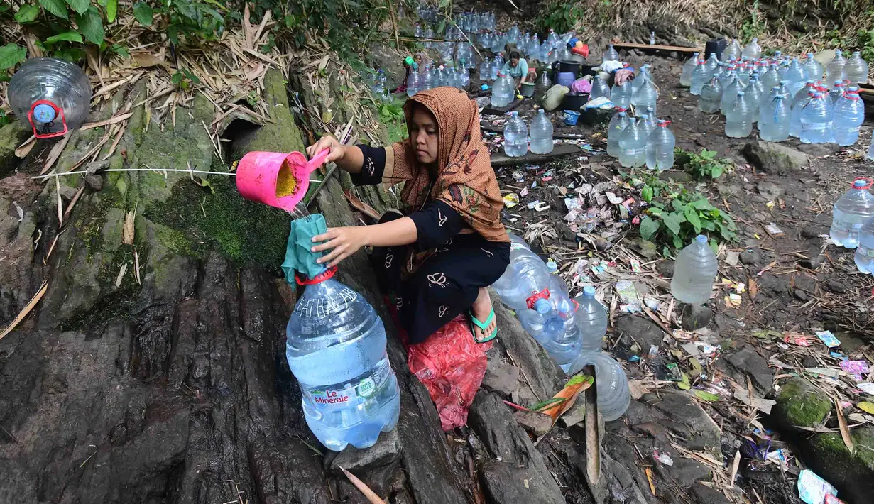 Warga  mengambil air untuk minum dan kebutuhan mck rumah  di sumber mata air Sumur Bendung, Gunung Batur, Kota Cilegon, Banten, Minggu, (15/7/2026). (KLY/Arie Basuki)