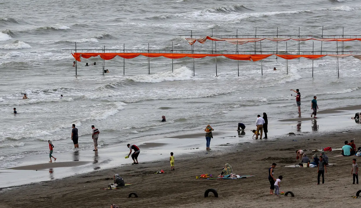 Warga Iran saat bermain di pantai di kota Laut Kaspia, Izadshahr, provinsi Mazandaran utara (8/7/2019). Terdapat lima negara yang membatasi Laut Kaspia. Selain Iran, semuanya adalah bekas negara-negara Uni Soviet. (AFP Photo/Atta Kenare)