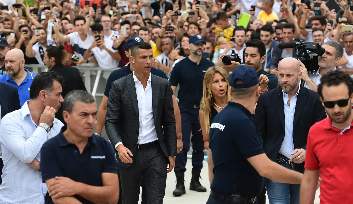 Para suporter menyambut kedatangan bintang baru Juventus, Cristiano Ronaldo, saat tiba untuk menjalani tes kesehatan di area Stadion Allianz, Turin, Senin (17/7/2018). CR 7 hijrah dari Real Madrid ke Juventus. (AFP/Miguel Medina)