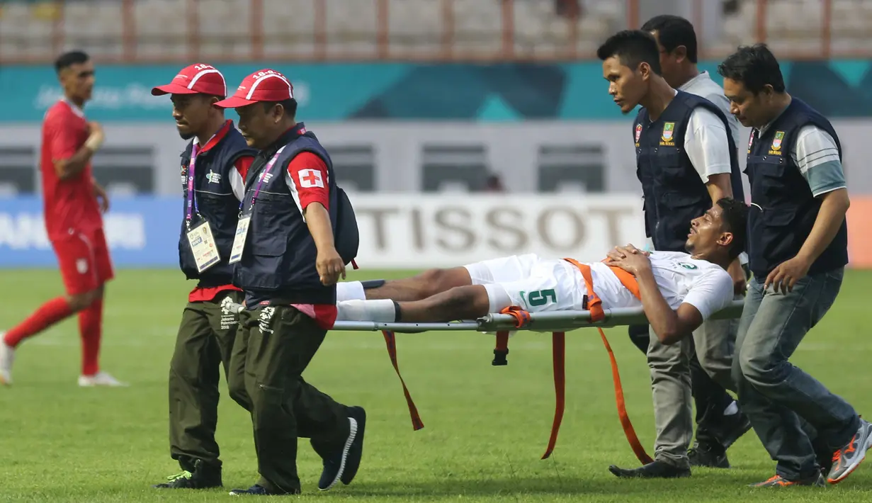 Pesepak bola Arab Saudi, Alamri Abdulelah Ali ditandu keluar lapangan oleh tim medis saat babak penyisihan Grup F Asian Games 2018 di Stadion Wibawa Mukti, Cikarang, Jawa Barat, Rabu (15/8). (INASGOC/Djuli Pamungkas/18)