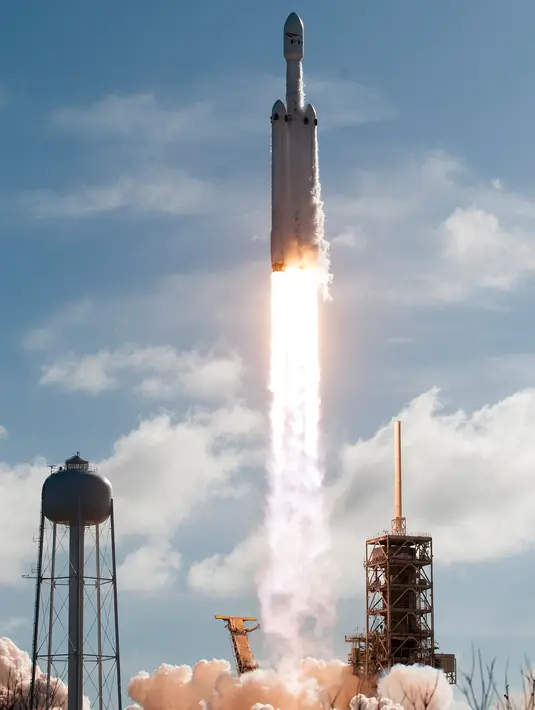 Falcon Heavy milik SpaceX meluncur saat penerbangan uji coba di Kennedy Space Center di Florida (6/2). Tesla Roadster tersebut berpenumpang manekin berpakaian astronot yang duduk di kursi pengemudi. (AFP/Jim Watson)