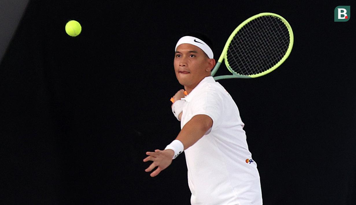 <p>Rezky Aditya berusaha mengembalikan bola dalam pertandingan tenis tunggal putra Turnamen Olahraga Selebriti Indonesia melawan Randy Pangalila yang berlangsung di Gelanggang Olahraga UNJ, Rawamangun, Jakarta Timur, Sabtu (29/7/2023). (Bola.com/Abdul Aziz)</p>