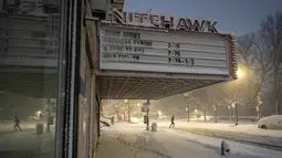 Badan Layanan Cuaca Nasional (NWS) melaporkan intensitas salju yang turun sangat ekstrem, mencapai lima hingga tujuh sentimeter per jam. Tampak dalam foto, seorang pelari berlari melewati Nitehawk Cinema di distrik Brooklyn, Kota New York, sebelum matahari terbit pada Senin 23 Februari 2026. (Jeremy Weine/Getty Images North America/Getty Images via AFP)