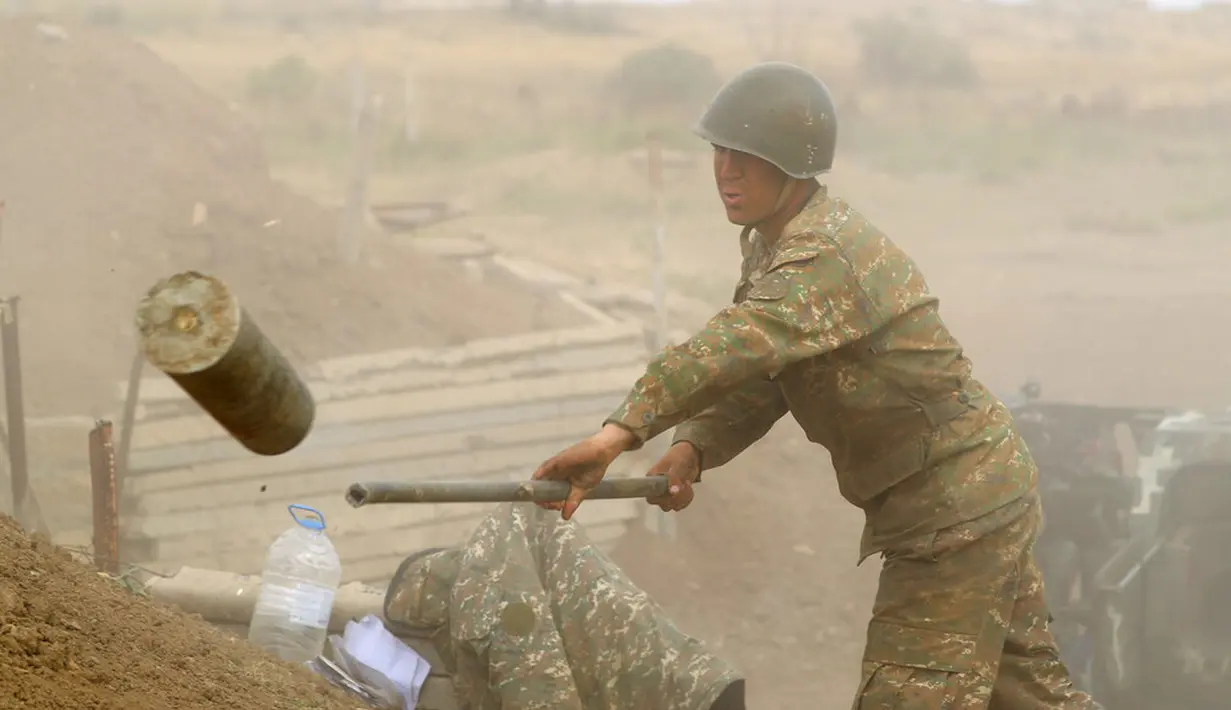 Tentara Armenia melempar selongsong peluru saat menembakkan meriam ke Azerbaijan di Republik Nagorno-Karabakh, Azerbaijan, Selasa (29/9/2020). Pasukan Armenia dan Azerbaijan saling serang saat memperebutkan Nagorno-Karabakh. (Sipan Gyulumyan/Armenian Defense Ministry Press Service/PAN Photo via AP)
