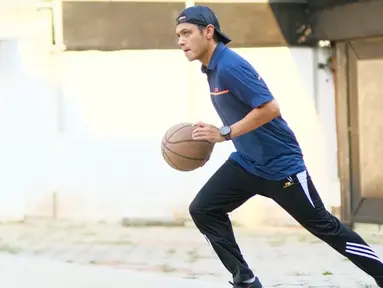 Dude Harlino kerap mengajak istri dan anak-anaknya untuk berolahraga. Mulai dari jalan di pagi hari hingga bermain basket. Dalam kesempatan ini, pria kelahiran 2 Desember 1980 tersebut tengah asyik menggiring bola basket. Dengan balutan pakaian sporty, Dude tampil penuh energi. (Liputan6.com/IG/@dude2harlino)