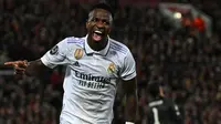 Pemain Real Madrid, Vinicius Jr melakukan selebrasi setelah mencetak gol penyeimbang 2-2 melalui blunder kiper Liverpool, Alisson Becker saat laga leg pertama Liga Champions 2022/2023 melawan Real Madrid yang berlangsung di Anfield, Rabu (22/02/2023) WIB. Liverpool kalah dengan skor 2-5 dari Real Madrid. (AFP/Paul Ellis)