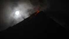Gerhana bulan "super blue blood moon" terlihat di samping Gunung Mayon yang mengeluarkan lava panas di Legazpi, Filipina (1/2). Pemandangan supermoon di mana bulan berada di jarak terdekat dengan bumi terlihat di sejumlah negara. (AFP Photo/Ted Aljibe)