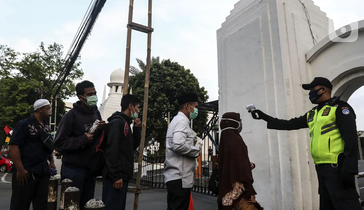 Petugas memeriksa suhu tubuh jemaah yang akan salat Idul Adha 1441 H di Masjid Al-Azhar, Jakarta, Jumat (31/7/2020). Pelaksanaan salat Id dilakukan secara berjemaah di masjid atau lapangan dengan menerapkan protokol kesehatan, seperti mengenakan masker dan menjaga jarak. (Liputan6.com/Johan Tallo)