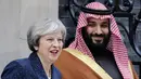 Perdana Menteri Inggris, Theresa May berpose dengan Putra Mahkota Arab Saudi, Pangeran Mohammed bin Salman saat menyambut kunjungannya di 10 Downing Street, London, Rabu (7/3). Inggris menyambut hangat kunjungan Pangeran Saudi itu. (Tolga AKMEN/AFP)