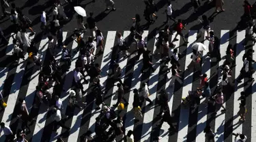 Pejalan kaki berjalan melintasi Shibuya Crossing yang juga disebut sebagai persimpangan pejalan kaki tersibuk dunia, di Tokyo, 13 Juni 2019. Di Shibuya Crossing ini juga dijadikan lokasi syuting dari film Fast & Farious: Tokyo Drift. (AP Photo/Jae C. Hong)