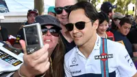 Seorang penggemar melakukan selfie dengan pembalap kawakan asal Tim Williams, Felipe Massa menjelang sesi latihan bebas pertama di Grand Prix Australia, Melbourne, Jumat (24/3). (AFP Photo/WILLIAM WEST)