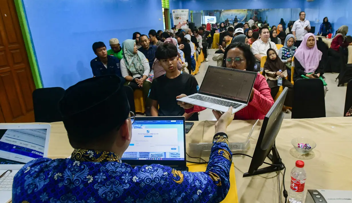 Petugas melayani orang tua calon siswa yang mencari informasi mengenai Sistem Penerimaan Murid Baru (SPMB) Tahun Ajaran 2026/2027 di Posko Pelayanan SPMB Suku Dinas Pendidikan Wilayah III yang berada di SMAN 70 Jakarta, Rabu (17/6/2026). (merdeka.com/Arie Basuki)