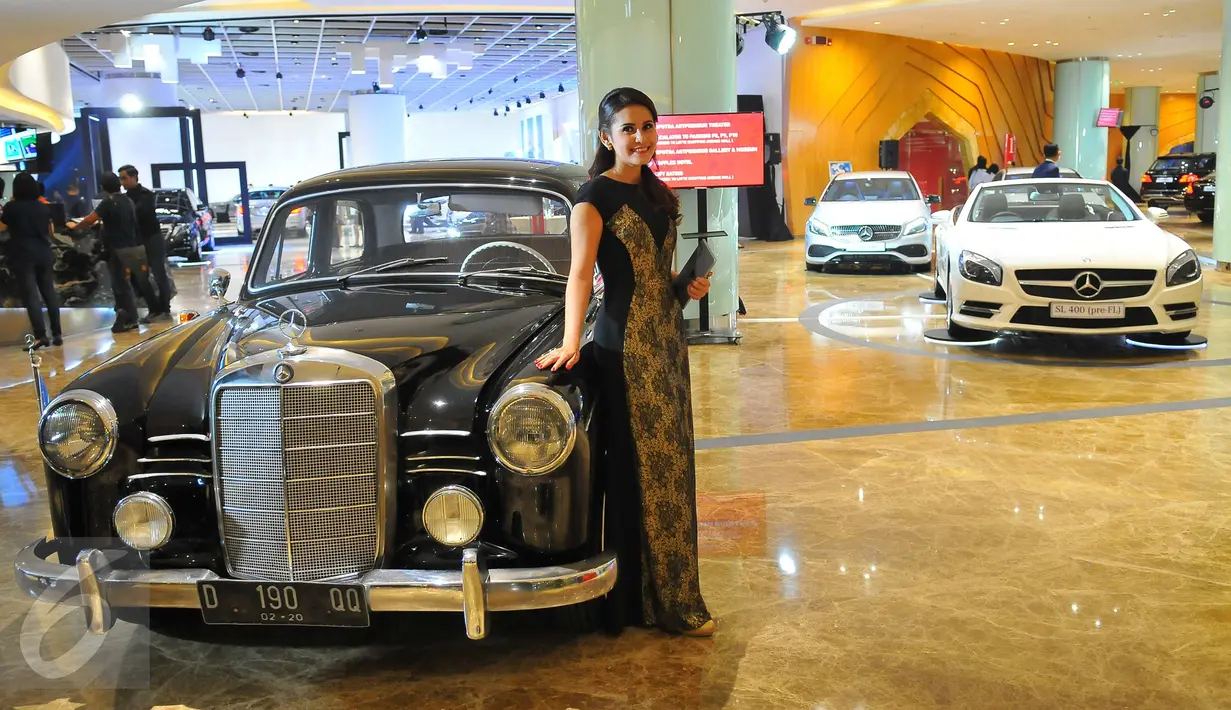 Model berpose di dekat mobil keluaran lama Mercedes Benz di Star Expo 2016,Jakarta, Rabu (23/11). Pameran tersebut merupakan pameran independen pertama dan terbesar bagi Mercedes Benz di Indonesia. (Liputan6.com/Angga Yuniar)