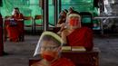 Para biksu muda mengenakan masker dan pelindung wajah saat belajar agama di Molilokayaram Educational Institute, Bangkok, Thailand, Rabu (15/4/2020). Sekitar 200 biksu muda tetap bersekolah kendati Thailand menutup semua sekolah selama lockdown akibat COVID-19. (AP Photo/Gemunu Amarasinghe)