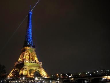 Menara Eiffel diterangi dengan warna-warna khas Ukraina untuk menandai peringatan satu tahun invasi Rusia ke negara tersebut, di Paris, Kamis, 23 Januari 2023. Invasi Rusia ke Ukraina merupakan salah satu yang terbesar di Eropa sejak Perang Dunia II, ratusan ribu jiwa menjadi korban di kedua pihak, serta menciptakan krisis pengungsi terbesar di Eropa. (AP Photo/Christophe Ena)