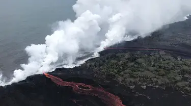 Lava pijar Gunung Kilauea saat mengalir ke laut di dua lokasi dekat Pahoa, Hawaii, Amerika Serikat, Senin (21/5). Lava pijar mengalir ke laut dan memicu reaksi kimia yang menciptakan awan raksasa asam dan kaca halus. (Survei Geologi AS via AP)