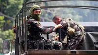 Pasukan pemerintah melakukan operasi militer untuk melawan militan yang mengepung kota Marawi di kota Bal-oi, Filipina selatan (26/5). Militer mengatakan telah menyelamatkan 120 orang dari sebuah sekolah dan rumah sakit. (AP Photo / Bullit Marquez)