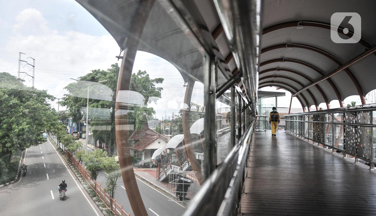 Operator menggunakan fasilitas jembatan penyeberangan orang (JPO) di Jalan Kolonel Sugiono, Duren Sawit, Jakarta Timur, Senin (7/2/2022). JPO Kolonel Sugiono yang berada dekat Kanal Banjir Timur itu didesain dengan bentuk yang modern namun sarat kearifan lokal. (merdeka.com/Iqbal S Nugroho)
