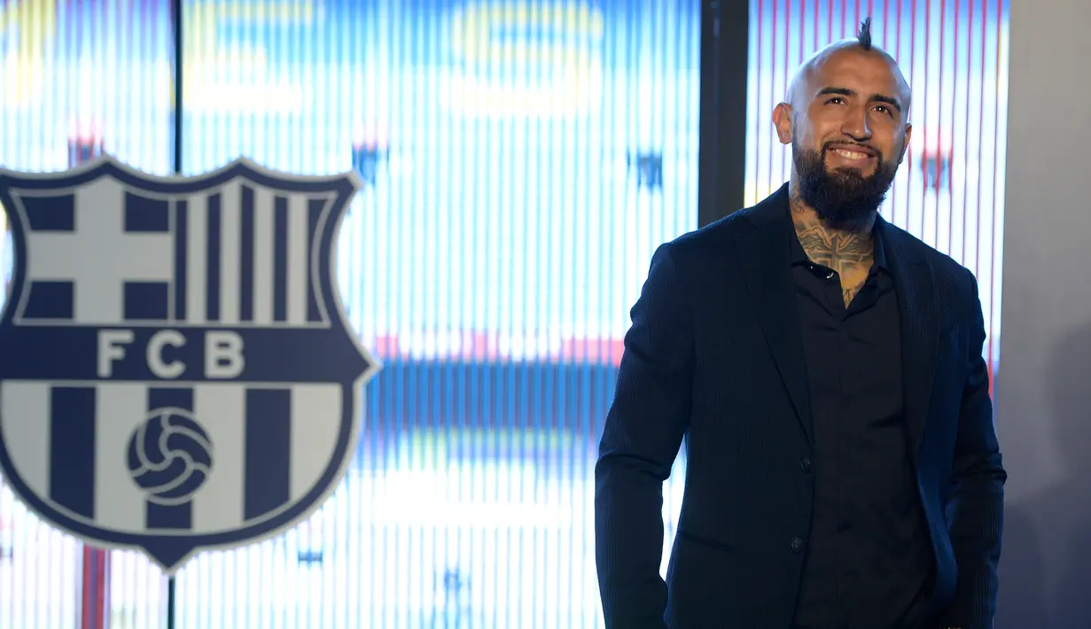 Pemain baru Barcelona, Arturo Vidal tersenyum saat presentasi resminya di Stadion Camp Nou, Barcelona, Spanyol, Senin (6/8). (Josep LAGO/AFP)