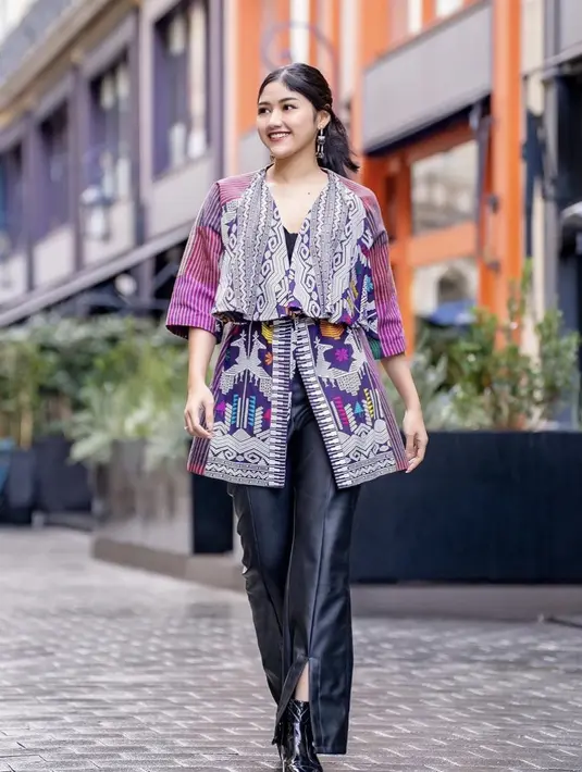 Atasan tersebut dipadukan dengan celana panjang kulit dengan detail slit yang dibuat oleh pengrajin di Garut. Penampilan Erina dilengkapi anting-anting dari Rinaldy Yunardi. Credit: Instagram/(@erinagudono)