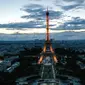 Foto udara dari lukisan raksasa "Beyond Walls" karya seniman jalanan Prancis, Saype, yang terbentang di halaman Champs de Mars, depan Menara Eiffel di Paris, 13 Juni 2019. Karya berukuran 600 meter itu bentuk dukungan kepada organisasi amal penyelamat migran, SOS Mediterranee. (Eric FEFERBERG/AFP)