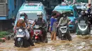 Pengendara menerobos banjir yang meggenang di Jalan Raya Bogor depan Pasar Induk Kramat Jati, Jakarta, Kamis (30/11/2023). (merdeka.com/Arie Basuki)