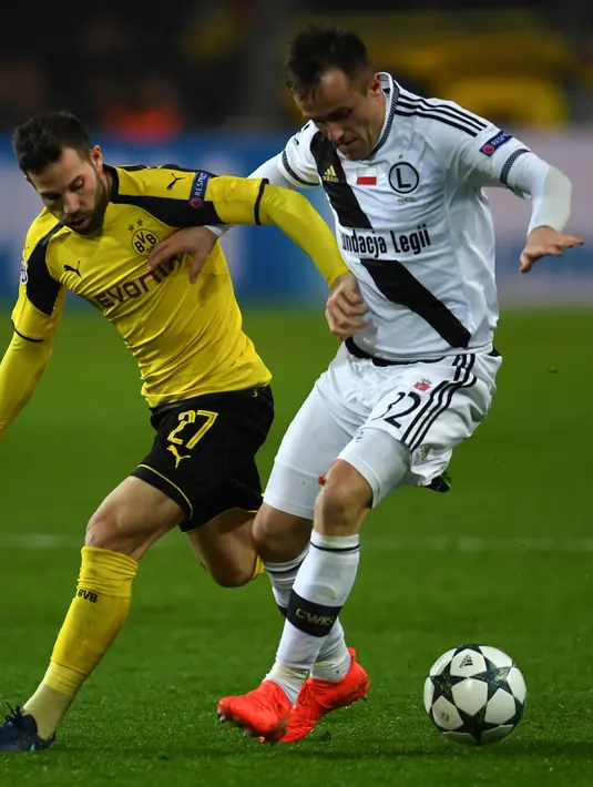 Gelandang Legia Warszawa, Miroslav Radovic berusaha mengontrol bola dari kawalan Gelandang Gonzalo Castro di Grup F Liga Champiosn di Signal Iduna Park, Jerman (23/11). Dortmund menang telak atas Legia dengan skor 8-4. (AFP Photo/Patrik Stollarz)
