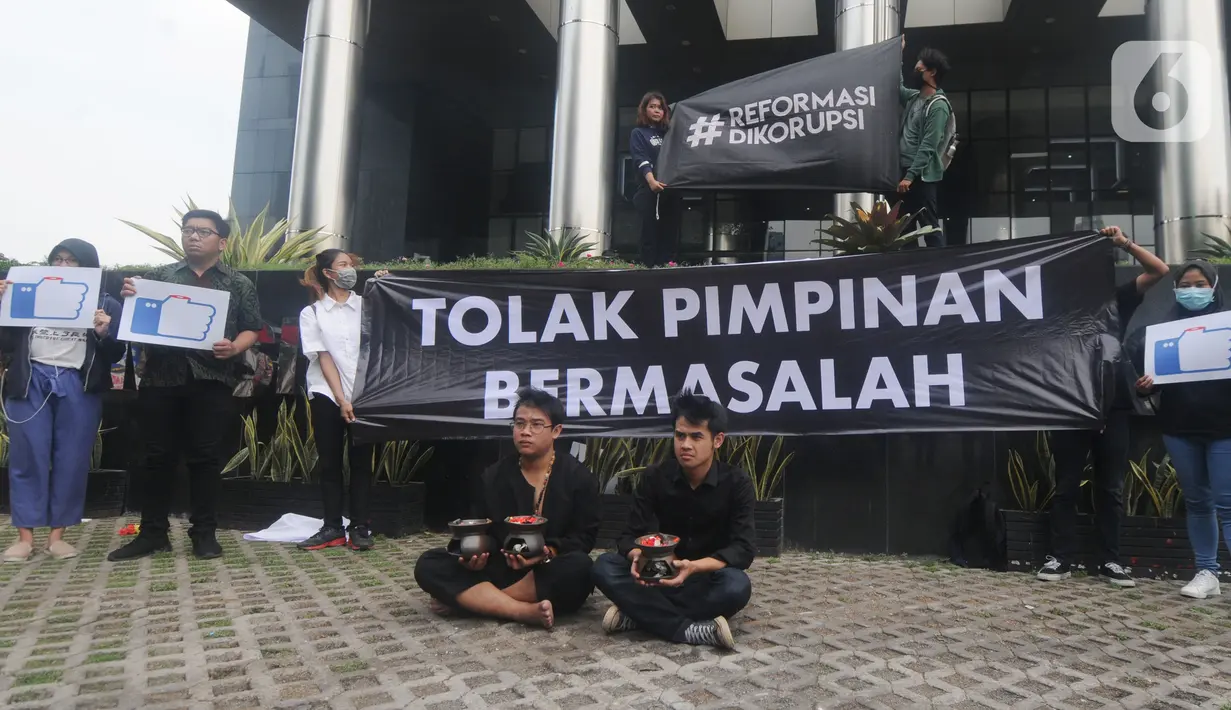 Aktivis dari Indonesia Corruption Watch (ICW) melakukan aksi teatrikal menolak kehadiran pimpinan KPK bermasalah di depan Gedung Merah Putih KPK, Jakarta, Jumat (20/12/2019). Aksi penolakan digambarkan dengan keberadaan dua dukun yang tengah mengusir roh jahat. (merdeka.com/Dwi Narwoko)