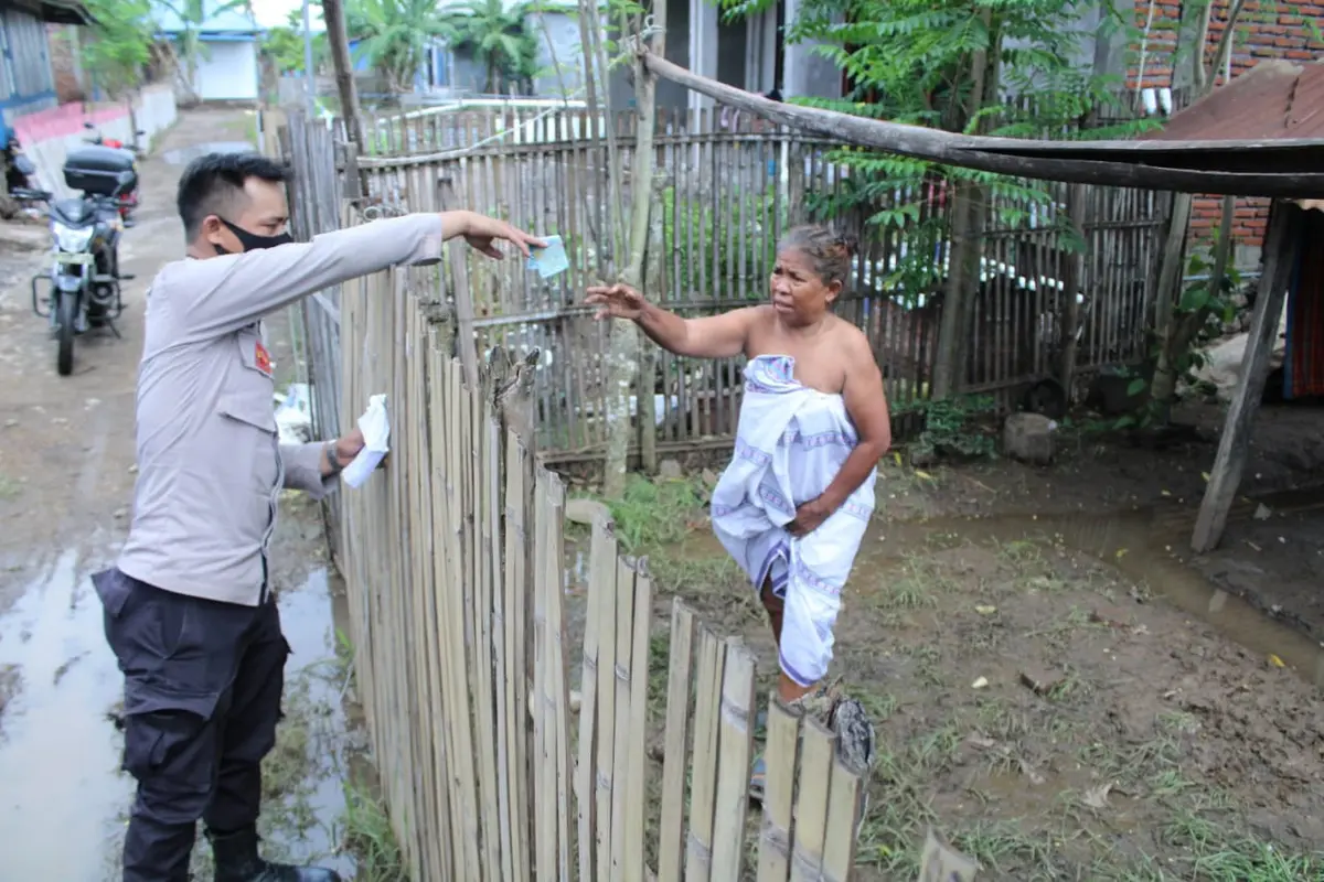 Aksi Pak Bhabin Supriyadin saat membagi-bagi uang kepada warga Bara, Dompu, yang merupakan hadiah dari Gubernur NTB. (Foto: Liputan6.com/Miftahul Yani)