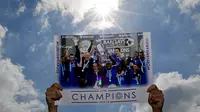 Aksi para pemain Leicester City saat mengelar parade juara, yang terefleksi via poster. Status juara tak membuat Leicester City mendapatkan pendapatan terbesar sepanjang 2015-2016. (Reuters/Tom Jacobs)