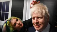 Artis Emma Meehan memberikan sentuhan akhir pada patung lilin PM Inggris Boris Johnson saat sesi pemotretan untuk pembukaannya di Madame Tussauds di Blackpool, Selasa (22/3/2022). Sosok Boris Johnson diletakkan di depan replika pintu depan Downing Street nomor 10 yang terkenal. (Paul ELLIS/AFP)